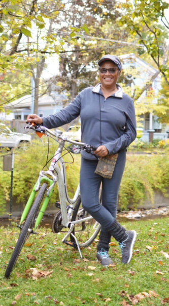 BIPOC person standing with bicycle