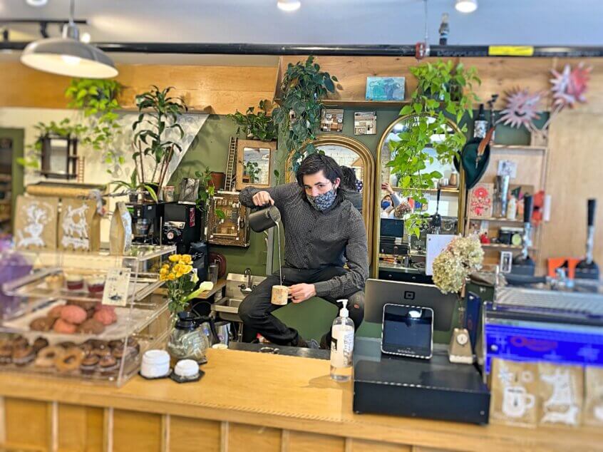 Caleb Harrington standing on the bar at Nothing Nowhere Cafe.