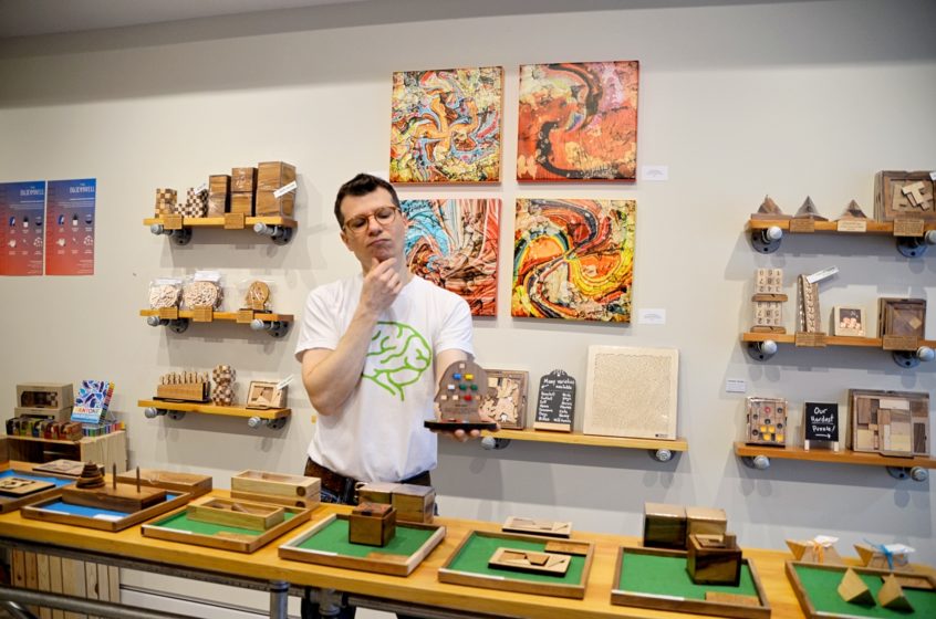 Man standing among various types of puzzles