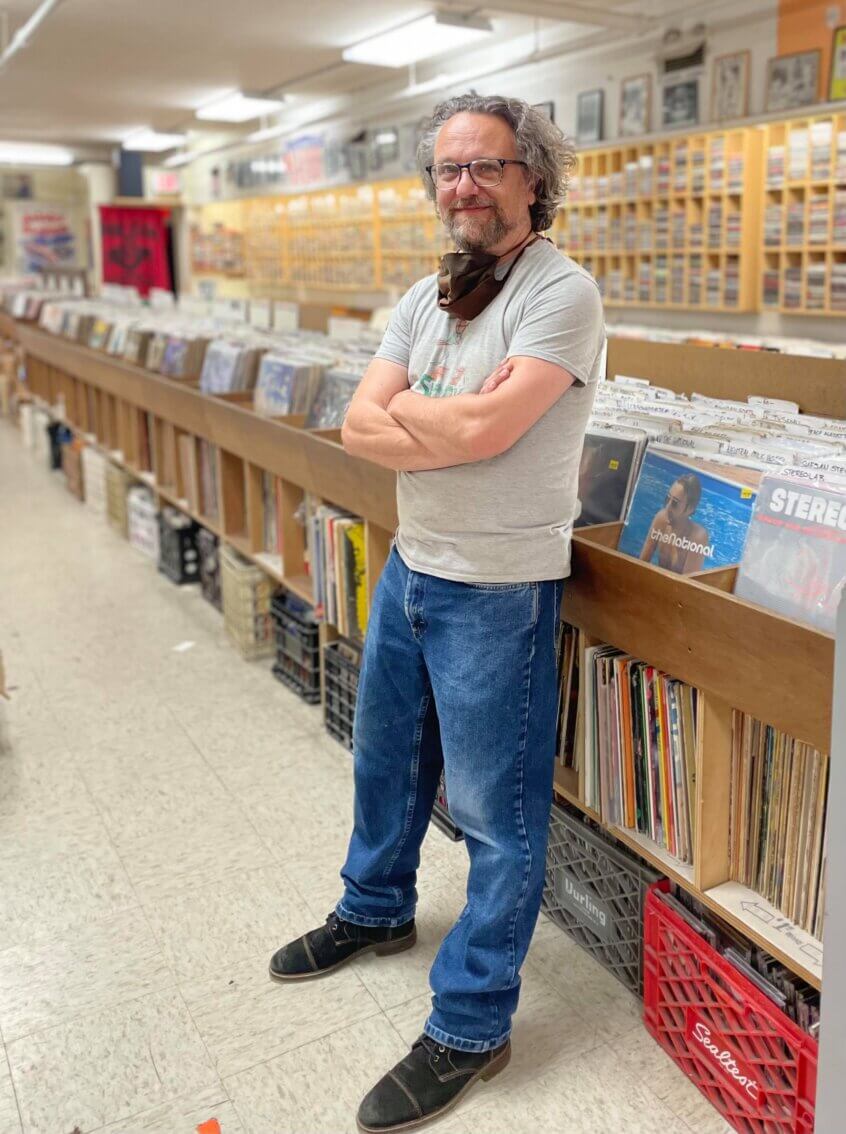 George standing near vinyl records